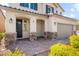 Inviting front of home with covered porch, stone accents, and a two-car garage at 9277 Ardoa Ave, Las Vegas, NV 89148