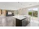 Open-concept kitchen with central island, wood-look floors and view to backyard at 9277 Ardoa Ave, Las Vegas, NV 89148