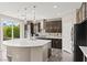 Modern kitchen with spacious center island, stainless steel appliances, and wood-look floors at 9277 Ardoa Ave, Las Vegas, NV 89148