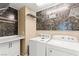 Functional laundry room with modern washer/dryer, storage cabinets, marble countertop and shelving at 9277 Ardoa Ave, Las Vegas, NV 89148