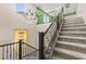 Staircase with carpeted steps and railing, illuminated by a chandelier and natural light at 9277 Ardoa Ave, Las Vegas, NV 89148