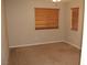 A simple bedroom with carpeted floors and horizontal blinds filtering natural light at 932 Tafalla Ct, Las Vegas, NV 89138