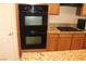 This kitchen features modern double ovens, light countertops, and a cooktop stove at 932 Tafalla Ct, Las Vegas, NV 89138