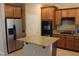 Well-equipped kitchen features an island, stainless steel refrigerator, and sleek black double ovens at 932 Tafalla Ct, Las Vegas, NV 89138