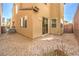 Wide shot of a gravel backyard with partial view of the home's exterior and a small patio at 9343 Clear Day Ln, Las Vegas, NV 89178
