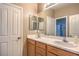 Bright bathroom featuring double sinks, wooden cabinets, and a large mirror at 9343 Clear Day Ln, Las Vegas, NV 89178