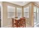 Dining area featuring tile flooring, three windows with blinds, and a dining table set with four chairs at 9343 Clear Day Ln, Las Vegas, NV 89178