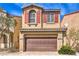 Inviting home featuring a two-car garage, red shutters, and desert landscaping in a suburban setting at 9343 Clear Day Ln, Las Vegas, NV 89178