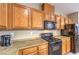 Kitchen featuring wood cabinets, black appliances, and tile floors at 9343 Clear Day Ln, Las Vegas, NV 89178