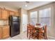 Kitchen with tile flooring, wooden cabinets, a dining table set, and a black refrigerator at 9343 Clear Day Ln, Las Vegas, NV 89178