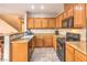 A kitchen featuring wood cabinets, tile floors, and a view of the staircase from the side at 9343 Clear Day Ln, Las Vegas, NV 89178