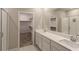 Bathroom featuring dual sinks, a large mirror, and a glass-enclosed shower at 9428 Noble Fir Ridge Ave, Las Vegas, NV 89143