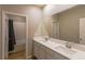 Bright bathroom featuring double sinks, white cabinets, and a shower/tub with tiled walls at 9428 Noble Fir Ridge Ave, Las Vegas, NV 89143