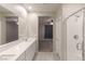 Bathroom featuring dual sinks, a large mirror, and a glass-enclosed shower at 9428 Noble Fir Ridge Ave, Las Vegas, NV 89143