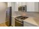 The stylish kitchen features stainless steel appliances, a gas range, and sleek quartz countertops at 9428 Noble Fir Ridge Ave, Las Vegas, NV 89143