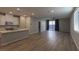 A light and bright living room features hardwood flooring and a view of the kitchen and outdoor space at 9428 Noble Fir Ridge Ave, Las Vegas, NV 89143