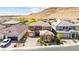Wide aerial view of the tan two-story home with two garages in a desert community at 9519 Wild Valley Ave, Las Vegas, NV 89148