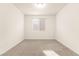 Bright bedroom featuring neutral carpet, a central window for natural light, and fresh white walls at 9519 Wild Valley Ave, Las Vegas, NV 89148