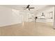 Open living room shows stairs, kitchen with white cabinets, a kitchen island, and stainless steel appliances at 9519 Wild Valley Ave, Las Vegas, NV 89148