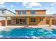 Backyard featuring a sparkling pool, covered patio, and tan two-story house with multiple windows on a sunny day at 9519 Wild Valley Ave, Las Vegas, NV 89148