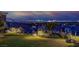 Inviting backyard featuring lush landscaping and panoramic views of the Las Vegas skyline at night at 10 Olympia Outlook Dr, Las Vegas, NV 89141