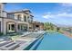Beautiful backyard with a modern pool, outdoor kitchen, and a spacious patio overlooking the scenic landscape at 10 Olympia Outlook Dr, Las Vegas, NV 89141