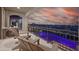 A balcony featuring comfortable seating and stunning sunset views overlooking the city and an infinity pool at 10 Olympia Outlook Dr, Las Vegas, NV 89141