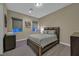 Cozy bedroom with a comfortable bed, carpeted floors, and two windows with privacy shades at 10 Olympia Outlook Dr, Las Vegas, NV 89141