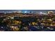 Panoramic nighttime view of the dazzling city skyline from an elevated vantage point amidst lush greenery and rooftops at 10 Olympia Outlook Dr, Las Vegas, NV 89141