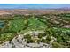 Aerial view of a luxurious golf course community, complete with lush fairways, manicured greens, and luxury homes at 10 Olympia Outlook Dr, Las Vegas, NV 89141