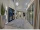 Spacious hallway with high ceilings, modern lighting, and glass doors, leading to various rooms in the house at 10 Olympia Outlook Dr, Las Vegas, NV 89141