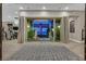 Grand living area with open glass doors leading to a outdoor living space with a statue and elegant seating at 10 Olympia Outlook Dr, Las Vegas, NV 89141