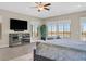 Bright main bedroom featuring a ceiling fan, dresser, and multiple windows with outdoor views at 10 Olympia Outlook Dr, Las Vegas, NV 89141
