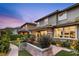 Exterior rear of home showcasing a landscaped yard, outdoor seating, and manicured landscaping at 10305 Turia Gardens Rd, Las Vegas, NV 89135