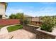 Backyard showcasing manicured lawn, lush landscaping, stone planters, and privacy fencing at 10305 Turia Gardens Rd, Las Vegas, NV 89135