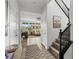 Bright foyer featuring wood flooring, a staircase with black railing, and views of the living area at 10305 Turia Gardens Rd, Las Vegas, NV 89135