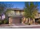 Charming two-story home featuring a two-car garage, stone accents, and manicured landscaping at 10305 Turia Gardens Rd, Las Vegas, NV 89135