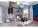 A creatively decorated bedroom featuring carpeted floors, bright wall art, and natural light from the window at 10325 Falls Church Ave, Las Vegas, NV 89144