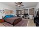 Comfortable bedroom with a ceiling fan, windows with wood shutters and a large area rug at 10325 Falls Church Ave, Las Vegas, NV 89144