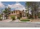Charming two-story home with a three-car garage and beautifully landscaped front yard on a sunny day at 10325 Falls Church Ave, Las Vegas, NV 89144