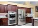 Gourmet kitchen featuring stainless steel appliances, dark wood cabinets, and double oven at 10325 Falls Church Ave, Las Vegas, NV 89144