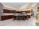Well-appointed kitchen with granite countertops, dark wood cabinets, tile flooring, and large island at 10325 Falls Church Ave, Las Vegas, NV 89144