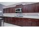 Close-up view of kitchen featuring dark wood cabinets, stainless steel appliances, and granite countertops at 10325 Falls Church Ave, Las Vegas, NV 89144