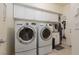 Convenient laundry room featuring modern washer and dryer units, cabinets and a utility sink at 10325 Falls Church Ave, Las Vegas, NV 89144