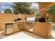 A well-equipped outdoor kitchen featuring a built-in grill, mini fridge, storage, and counter space at 10325 Falls Church Ave, Las Vegas, NV 89144