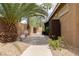 Landscaped side yard with decorative pots and a paved walkway leading to a private outdoor shower at 10325 Falls Church Ave, Las Vegas, NV 89144