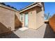 Rear exterior view of this charming home's gravel backyard, featuring a door and small patio at 1035 Spotted Saddle St, Henderson, NV 89015