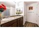 Bathroom with granite countertops, dark wood cabinets, dual mirrors, and a shower/tub combination at 1035 Spotted Saddle St, Henderson, NV 89015