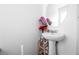Bathroom features a pedestal sink with a decorative round mirror at 1035 Spotted Saddle St, Henderson, NV 89015