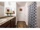 Bathroom featuring granite countertops, dark wood cabinets, dual mirrors, and a shower with decorative curtain at 1035 Spotted Saddle St, Henderson, NV 89015